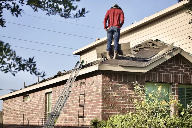 Professional roofer working on a residential roof in Raoul